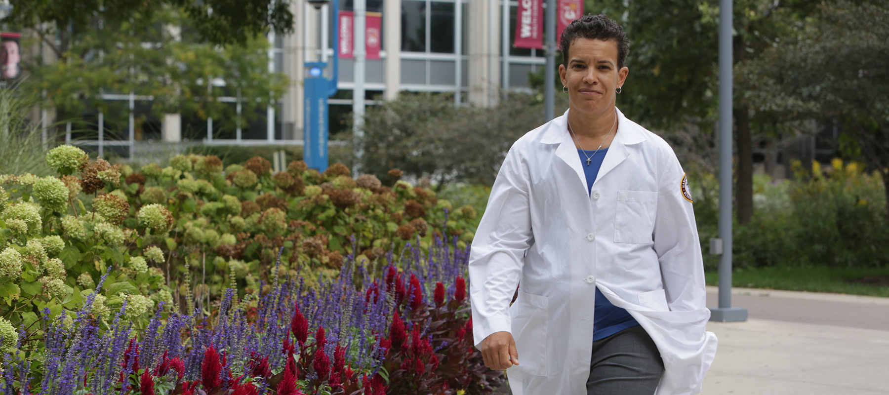 DNP graduate Erica Dixon-Johnson walks on the sidewalk at HSC